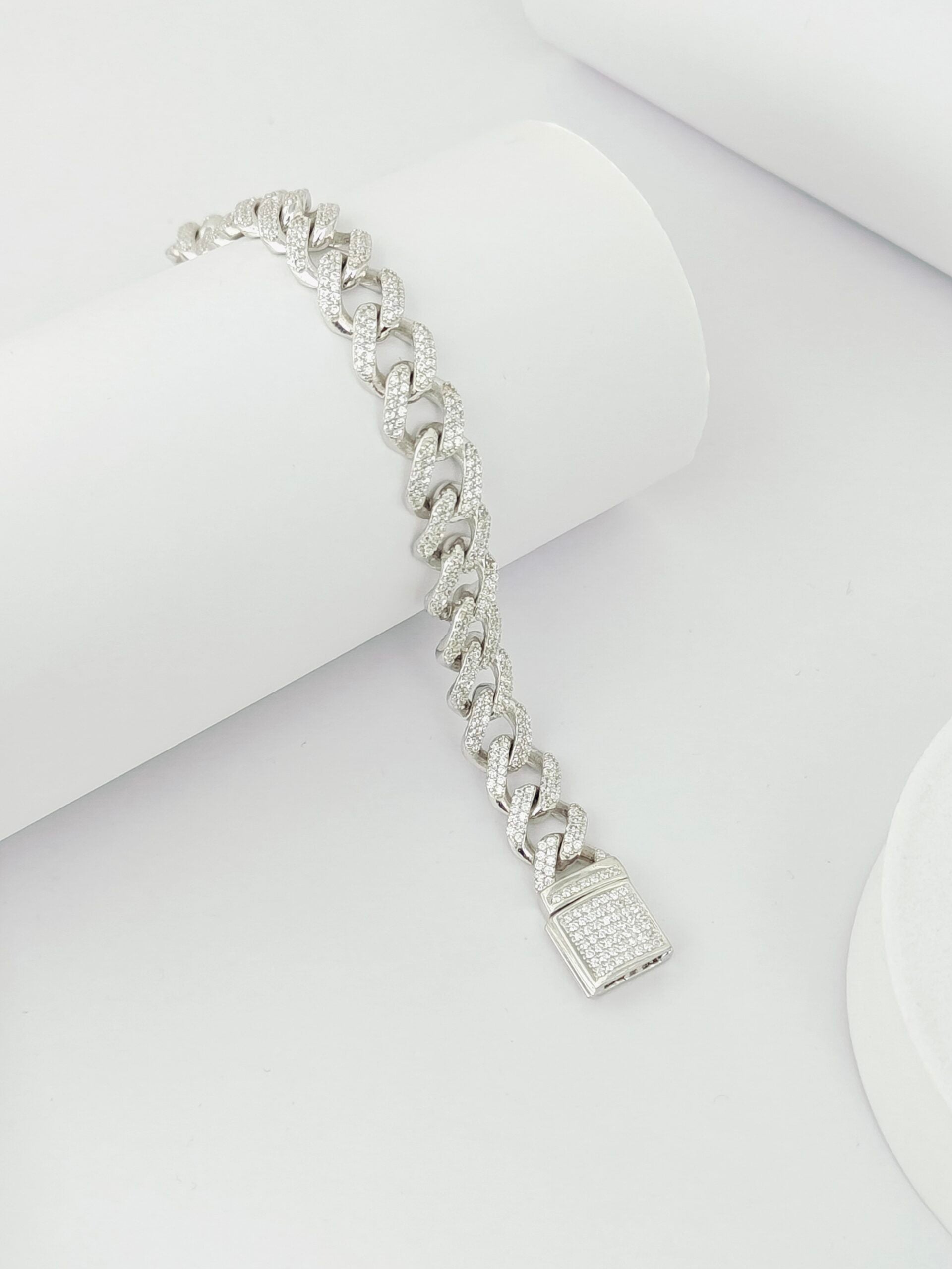 Silver bracelet with a lock charm on a white background